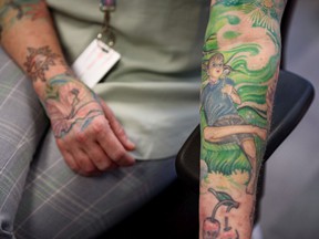 Lindsay Peace, executive director of Skipping Stones, shows her tattoo, which she had changed after her son came out as transgender, at her office in downtown Calgary on Thursday, May 26, 2022. Peace has tattoos of her three children on her arm and the one of her son Ace used to be wearing a pink dress. She had the tattoo changed by the help of her husband Steve Peace who is a tattoo artist.