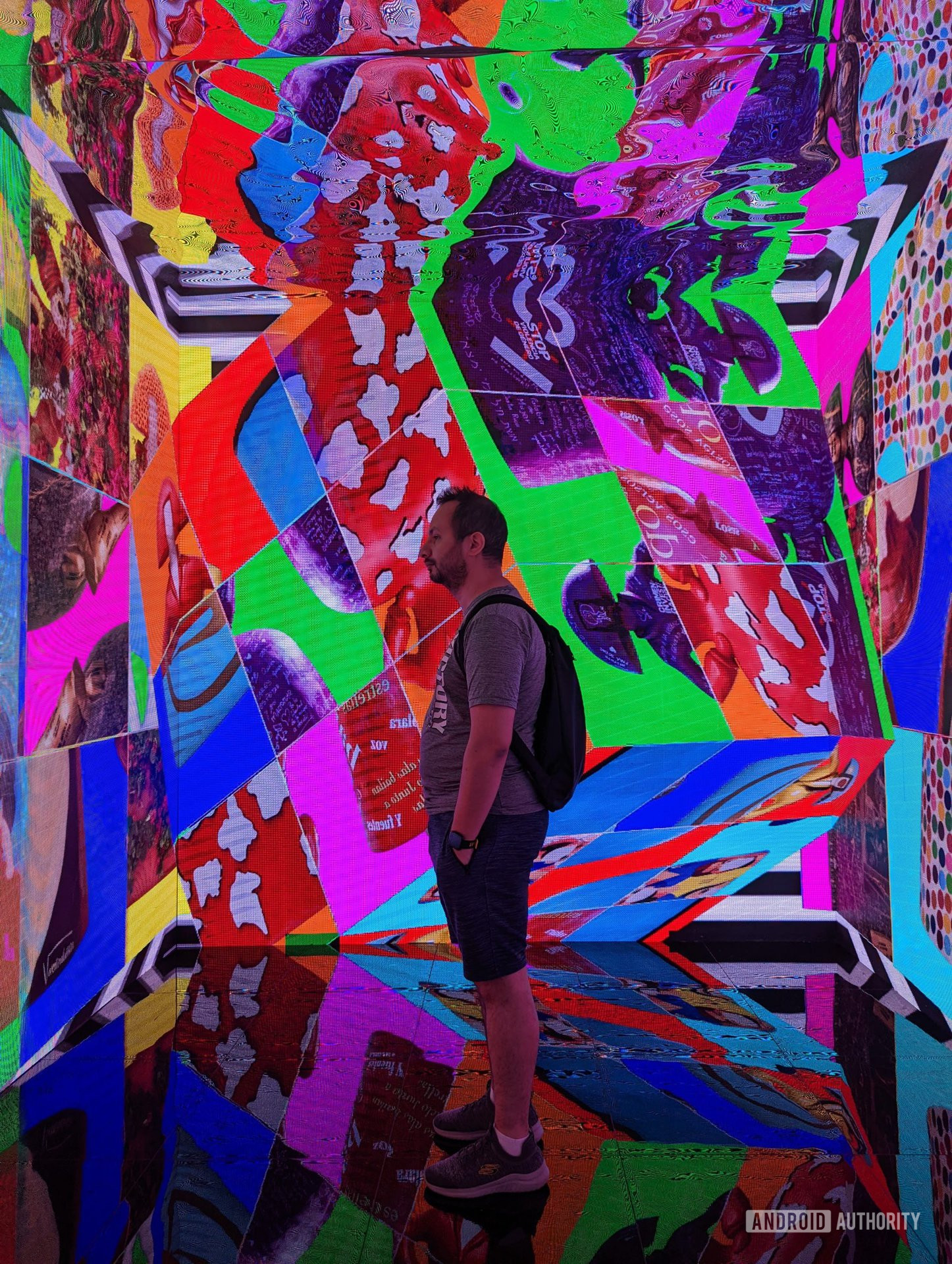 Man standing in a colorful psychedelic room with the Karry 3.0+ drawstring on his back